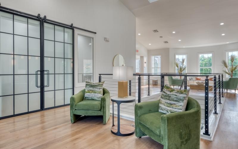 a room with a glass wall and a table with chairs and a lamp
