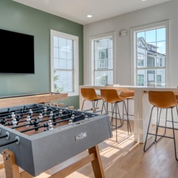 a room with game tables and a wall mounted tv