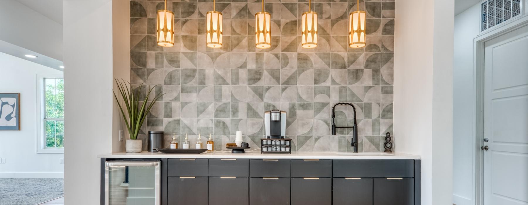 a coffee bar with a coffee maker sink and pendant lighting