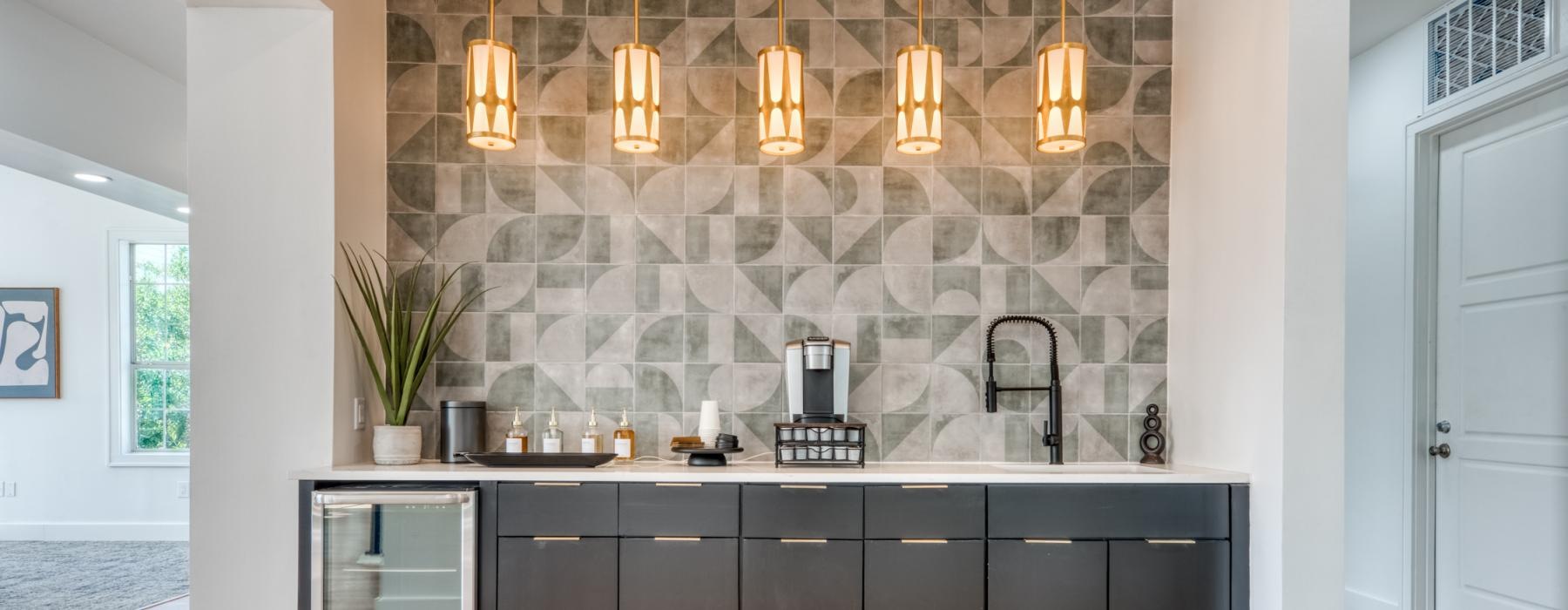 a coffee bar with a coffee maker sink and pendant lighting
